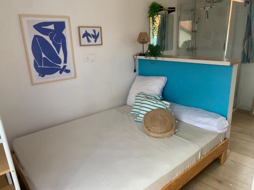 Ce lit se trouve dans un dortoir doté d'un mur bleu et blanc. dans l'établissement Jolie maisonnette à la plage avec extérieur et parking pr juillet et aout slmt, à Canet