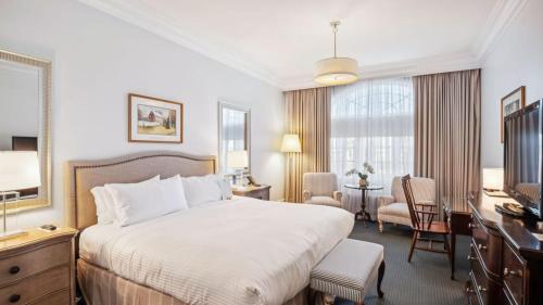 a hotel room with a large bed and a desk at Avon Old Farms Hotel in Avon