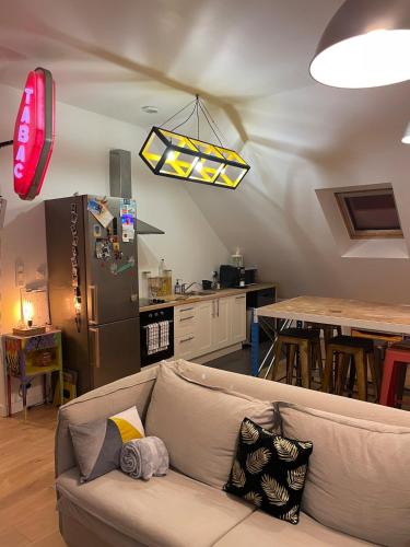 un salon avec un canapé et une cuisine dans l'établissement appartement complet, à Montoir-de-Bretagne