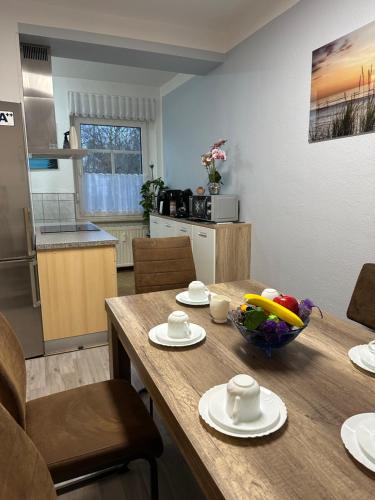 a kitchen with a wooden table with a bowl of fruit on it at Oppiner Straße 14 Trotha in Halle an der Saale