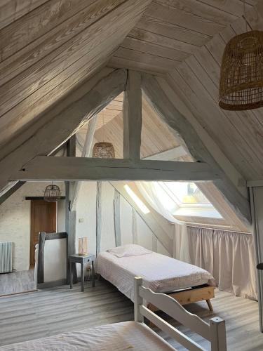 une chambre avec un lit dans un grenier dans l'établissement A la campagne, à Saint-Calez-en-Saosnois