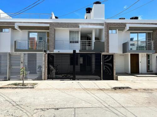 a large white house with a black gate at Apartamento moderno en Callejas – cómodo y bien ubicado in Valledupar