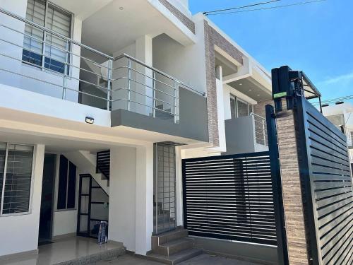 a modern house with a balcony and a gate at Apartamento moderno en Callejas – cómodo y bien ubicado in Valledupar