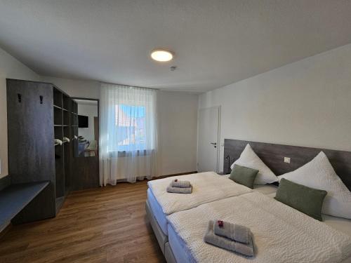 a bedroom with a large bed with towels on it at Regenbogen8 Ferienwohnungen in Linsengericht