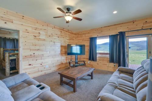 a living room with two couches and a television at Sportsman Lodge Melrose MT in Melrose