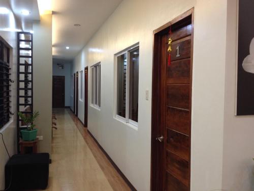 a hallway with a wooden door in a room at Seaslugs Travellers Inn in El Nido