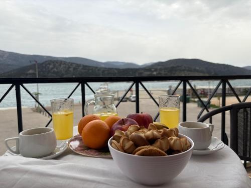 a table with a bowl of fruit and orange juice at Rouchotas Studios by Viktor 1rst Floor in Argostoli