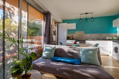un salon avec un canapé et une cuisine dans l'établissement Appartement calme avec terrasse et climatisation, à Nice
