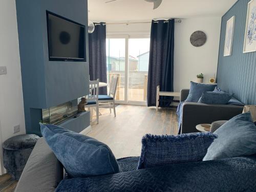 a living room with a couch and a tv at Beach Buoys holiday chalet Close to the dog friendly beach in Bridlington