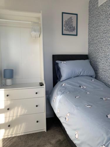une chambre avec un lit et une commode dans l'établissement Beach Buoys holiday chalet Close to the dog friendly beach, à Bridlington