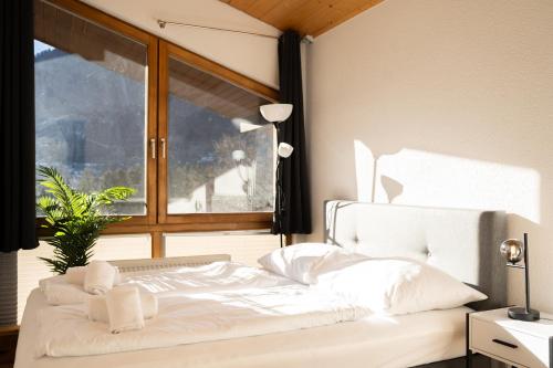 a white bed in a room with a window at homy Alpine Deluxe Chalet in St Anton im Montafon in Sankt Anton im Montafon