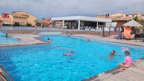 un groupe de personnes nageant dans une piscine dans l'établissement Grand T2 et jardin proche plages, à Lecci