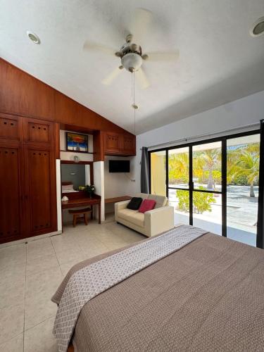a bedroom with a bed and a couch and windows at Beachfront department Celestun in Celestún