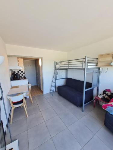 un salon avec un lit superposé et un canapé dans l'établissement Studio cabin at Port Camargue, au Grau-du-Roi