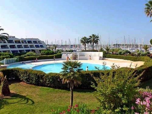 - une grande piscine dans une cour avec un complexe dans l'établissement Studio cabin at Port Camargue, au Grau-du-Roi