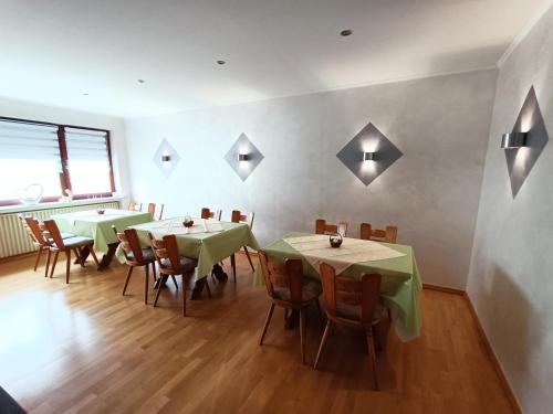 a dining room with tables and chairs and lights on the wall at Weingut Lindenhof in Thörnich