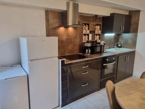 une cuisine avec un réfrigérateur blanc et une table dans l'établissement Danton, à Arles