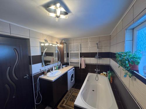 a bathroom with a tub and a sink and a bath tub at OliverHouse in Gura Humorului