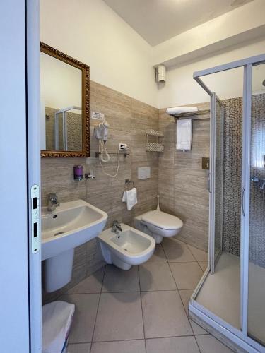 a bathroom with two sinks and a toilet and a shower at La Lanterna in Silvi Marina