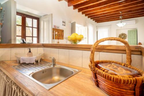 a kitchen with a sink and a basket on a counter at OURANIAS HOUSE in Kalymnos