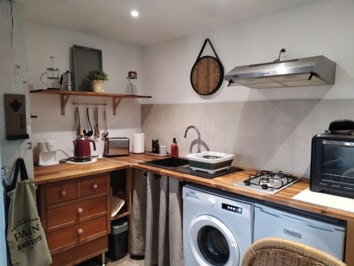 a kitchen with a washer and dryer on a counter at Vacances à Nova 1 in Martageix