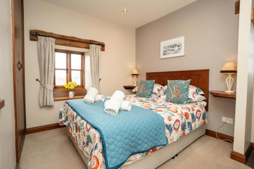 a bedroom with a bed and a window at Ystumgwern Luxury Barn Conversions in Dyffryn