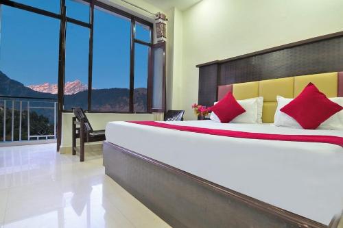 a bedroom with a large bed with red pillows at Hotel Hillora Mcleodganj in McLeod Ganj