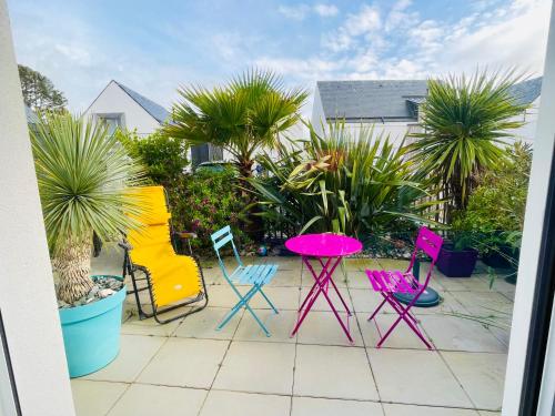 un groupe de chaises et une table sur une terrasse dans l'établissement plage et le marché à pieds, à Carnac