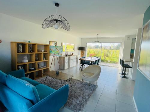 un salon avec un canapé bleu et une table dans l'établissement plage et le marché à pieds, à Carnac