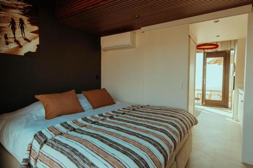 a bedroom with a bed with a striped blanket at Venti Beach Houses in Zandvoort