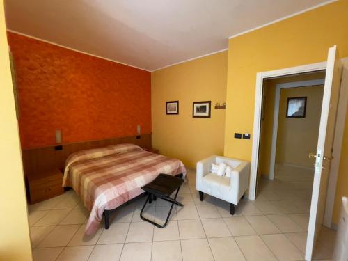a bedroom with a bed and a chair in it at La Lanterna in Silvi Marina
