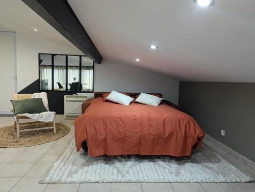 une chambre avec un grand lit et une chaise dans l'établissement Appartement T2, à Saint-Vincent-de-Paul