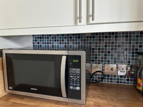 a microwave oven sitting on top of a kitchen counter at Cosy 2-Bed Retreat in Hampstead in London