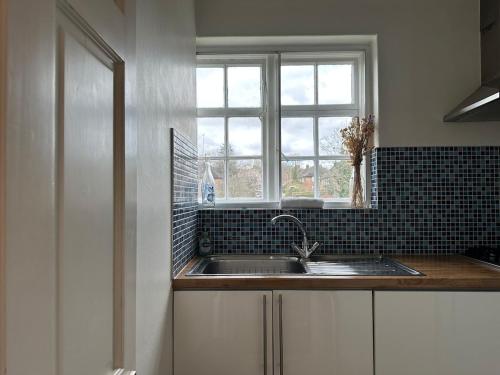 a kitchen with a sink and a window at Cosy 2-Bed Retreat in Hampstead in London