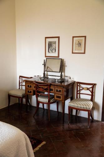 a desk with a mirror and two chairs in a room at Castello in Lucignano