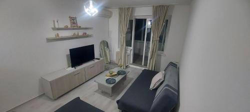 Una sala de estar con un sofá y un televisor. en K3 Apartment, en Skopje