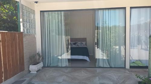 a balcony with sliding glass doors with a bed outside at Casa MonteFlor - Refúgio onde a vida desacelera com gentileza in Governador Celso Ramos