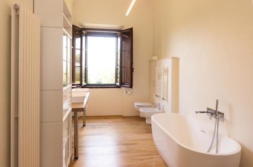 a bathroom with a tub and two toilets and a sink at Castello in Lucignano