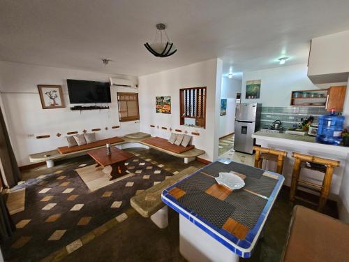 a living room with a table and a kitchen at Los Pinos de Zorritos Condominio in Zorritos