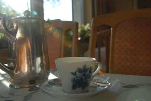 a tea kettle and a cup on a table at Hotel Schaumburg in Bad Pyrmont