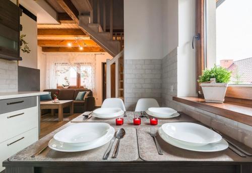 a kitchen with four white plates on a table at Domki Irena Kozdrowska in Polańczyk