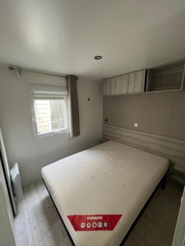 une chambre avec un lit dans une pièce avec une fenêtre dans l'établissement Mobilhome 3 Chambres 2 Salle de Bain, à Saint-Brévin-les-Pins