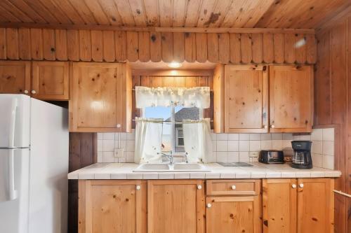 a kitchen with wooden cabinets and a sink at Sunnyside Combined 12BR 5BA Lakefront Retreat in Lincoln Junction