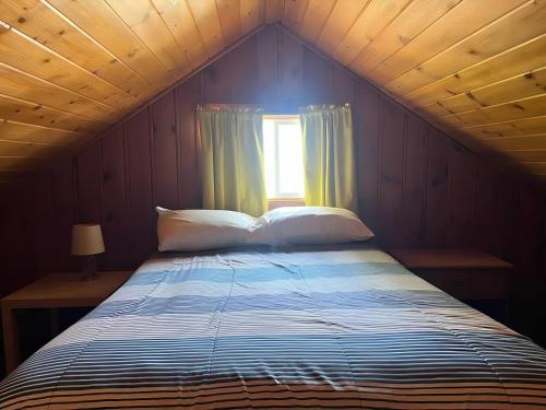 a large bed in a room with a window at Sunnyside Combined 12BR 5BA Lakefront Retreat in Lincoln Junction