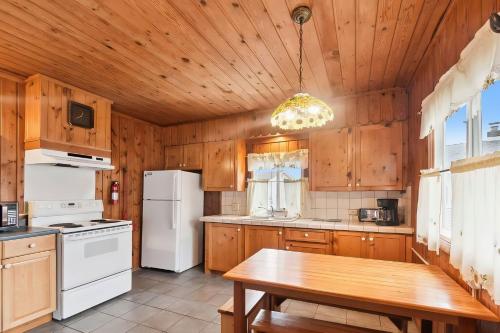 a kitchen with a white refrigerator and a wooden ceiling at Lakefront Cottages 4 & 5 - 6BR Retreat for 12 in Lincoln Junction