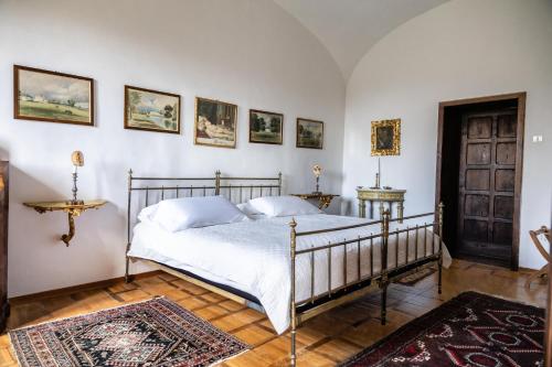 a bedroom with a bed and some pictures on the wall at Castello in Lucignano