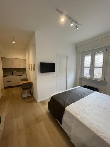 a bedroom with a bed and a desk and a television at Sirolo appartamenti in Sirolo