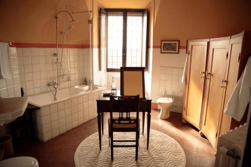 a bathroom with a table and a tub and a sink at Castello in Lucignano