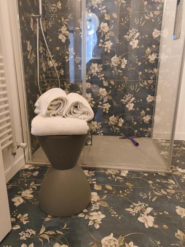 a bathroom with a shower with a pile of towels at Relaxing Break Lario in Gravedona