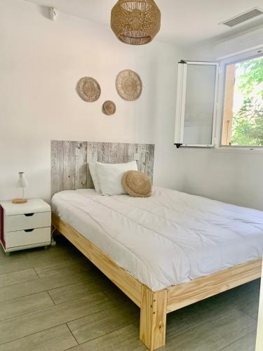 une chambre avec un grand lit avec une tête de lit en bois dans l'établissement Maison de standing avec jardin et parking près de la plage, à Canet